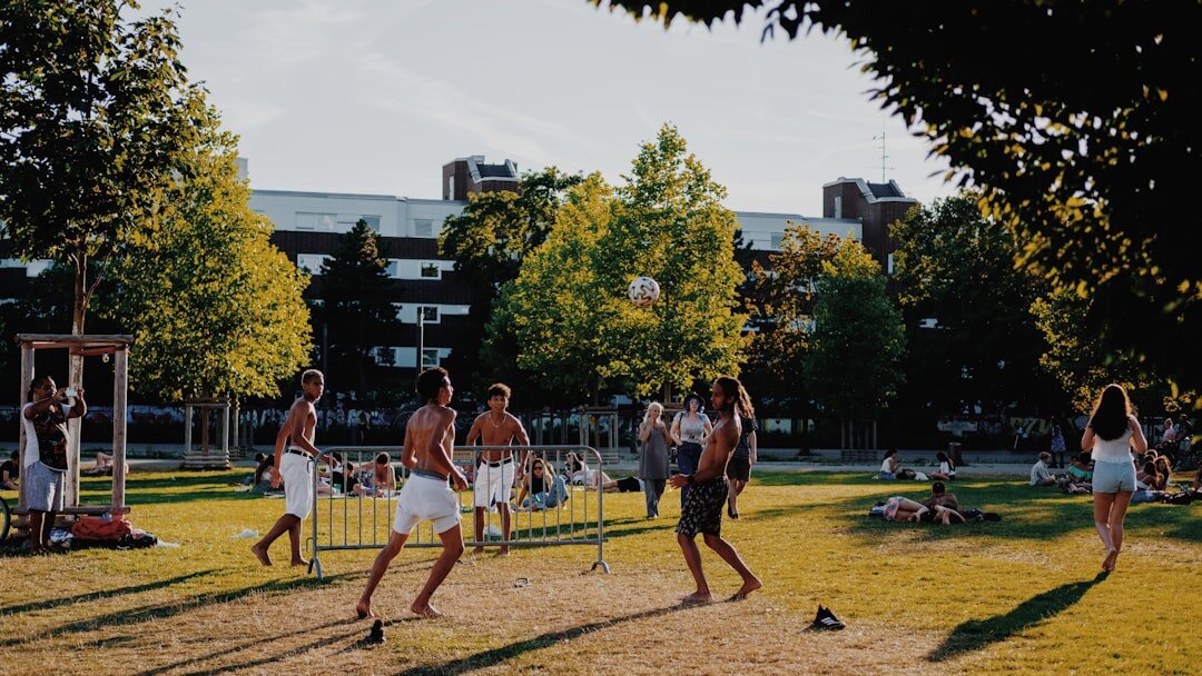 Diverse group of Brazilian friends laughing and jumping outdoors in a park